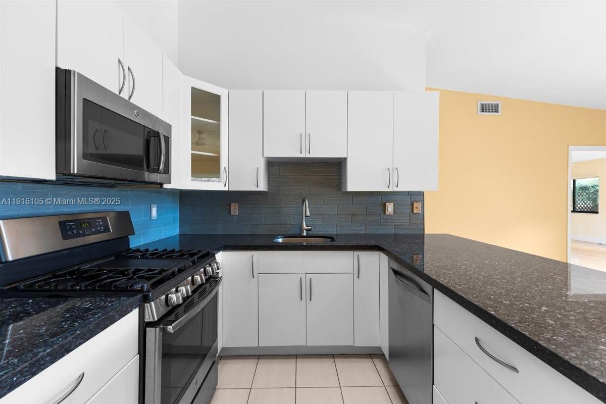 9231 Southwest 150th Avenue Miami, FL 33196 - Photo 16 of 51 a kitchen with stainless steel appliances granite countertop a sink stove and microwave