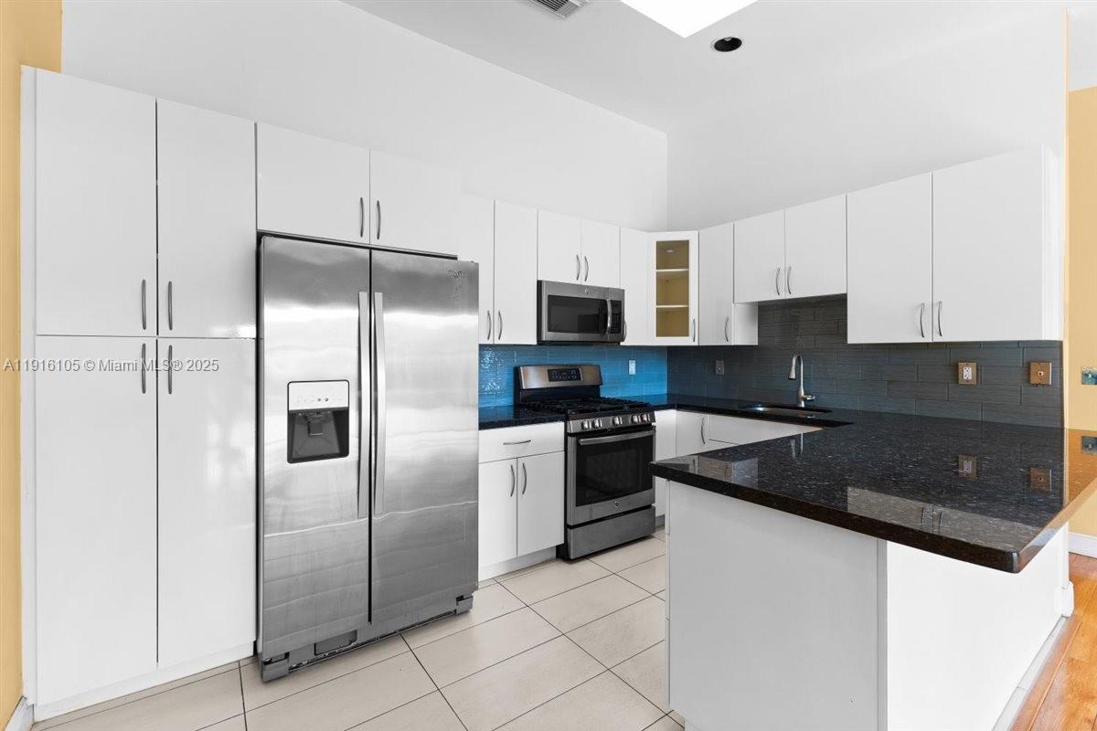 9231 Southwest 150th Avenue Miami, FL 33196 - Photo 17 of 51 a kitchen with a refrigerator and a stove top oven