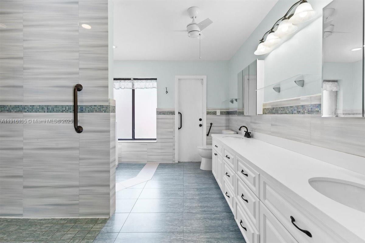 9231 Southwest 150th Avenue Miami, FL 33196 - Photo 27 of 51 a bathroom with a double vanity sink a mirror and a bathtub