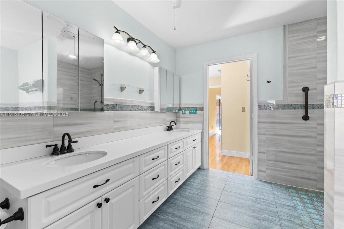9231 Southwest 150th Avenue Miami, FL 33196 - Photo 28 of 51 a bathroom with a double vanity sink mirror and shower