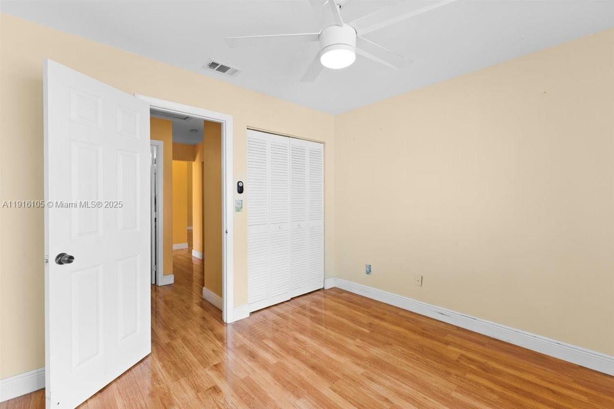 9231 Southwest 150th Avenue Miami, FL 33196 - Photo 35 of 51 an empty room with wooden floor and a ceiling fan