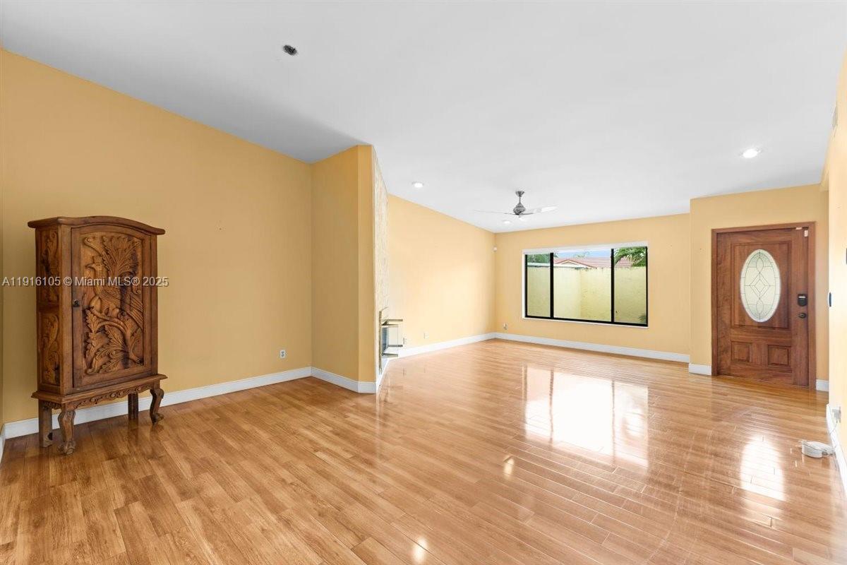 9231 Southwest 150th Avenue Miami, FL 33196 - Photo 9 of 51 a view of an empty room with wooden floor and a window