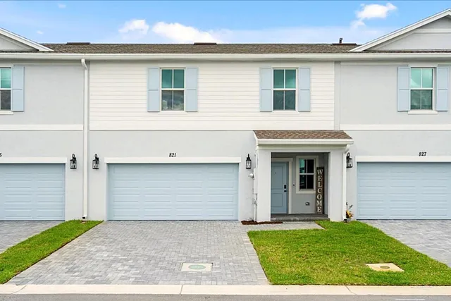 a view of a white house with a yard and garage