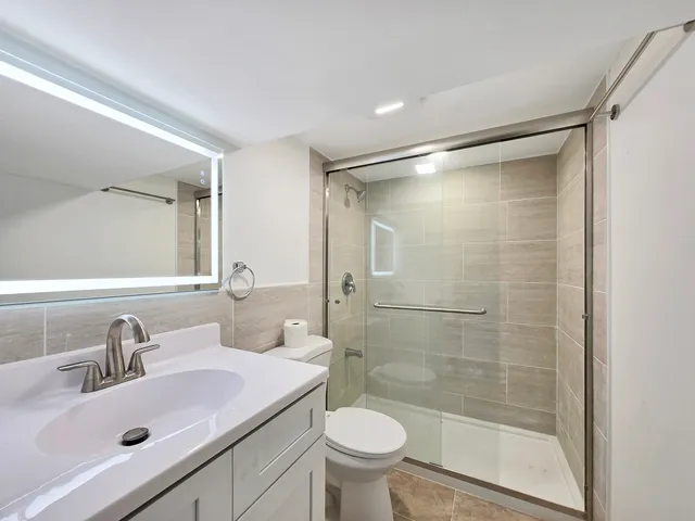 a bathroom with a sink toilet and shower