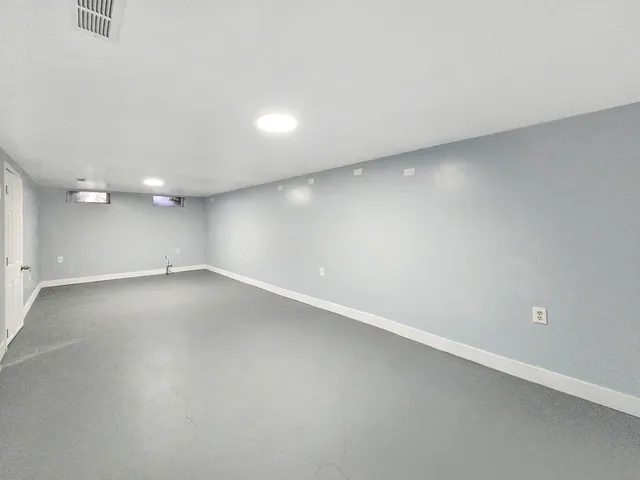 an empty room with a white wall and door