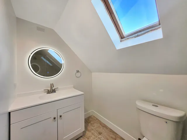 a bathroom with a sink a toilet and a mirror