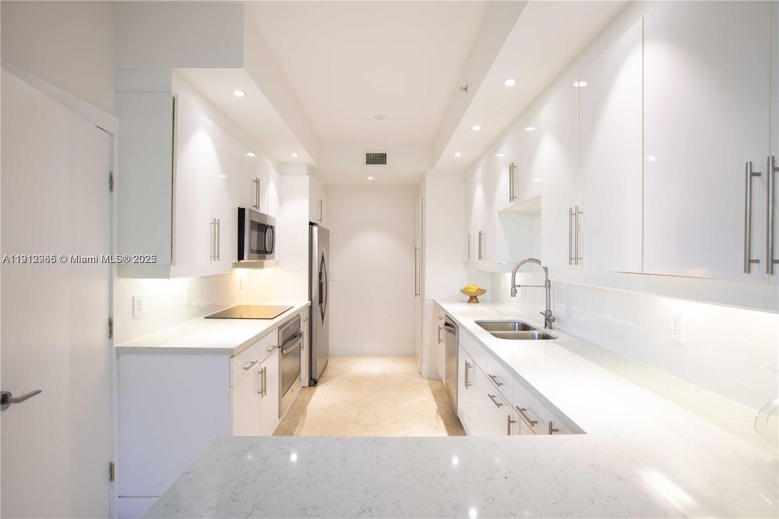 721 Crandon Boulevard, Unit 207 Key Biscayne, FL 33149 - Photo 7 of 8 a large white kitchen with a sink