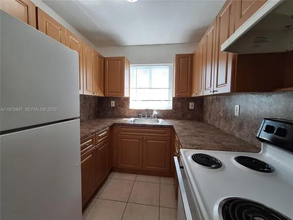 a kitchen with a sink a stove and a microwave