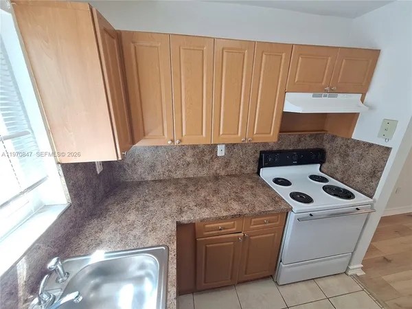 a kitchen with granite countertop cabinets stainless steel appliances a sink and a window