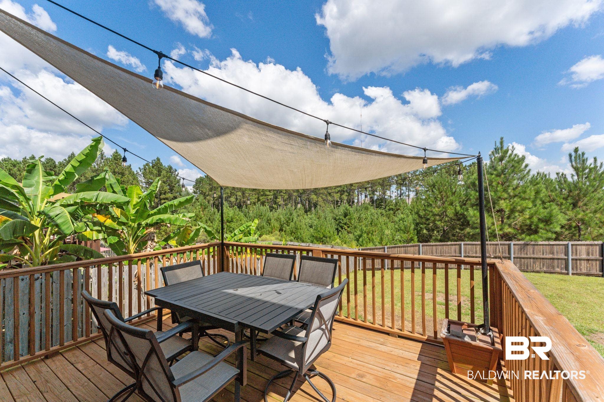 12711 Chickadee Lane Daphne, AL 36527 - Photo 30 of 39 Wooden deck with a fenced backyard and outdoor dining area