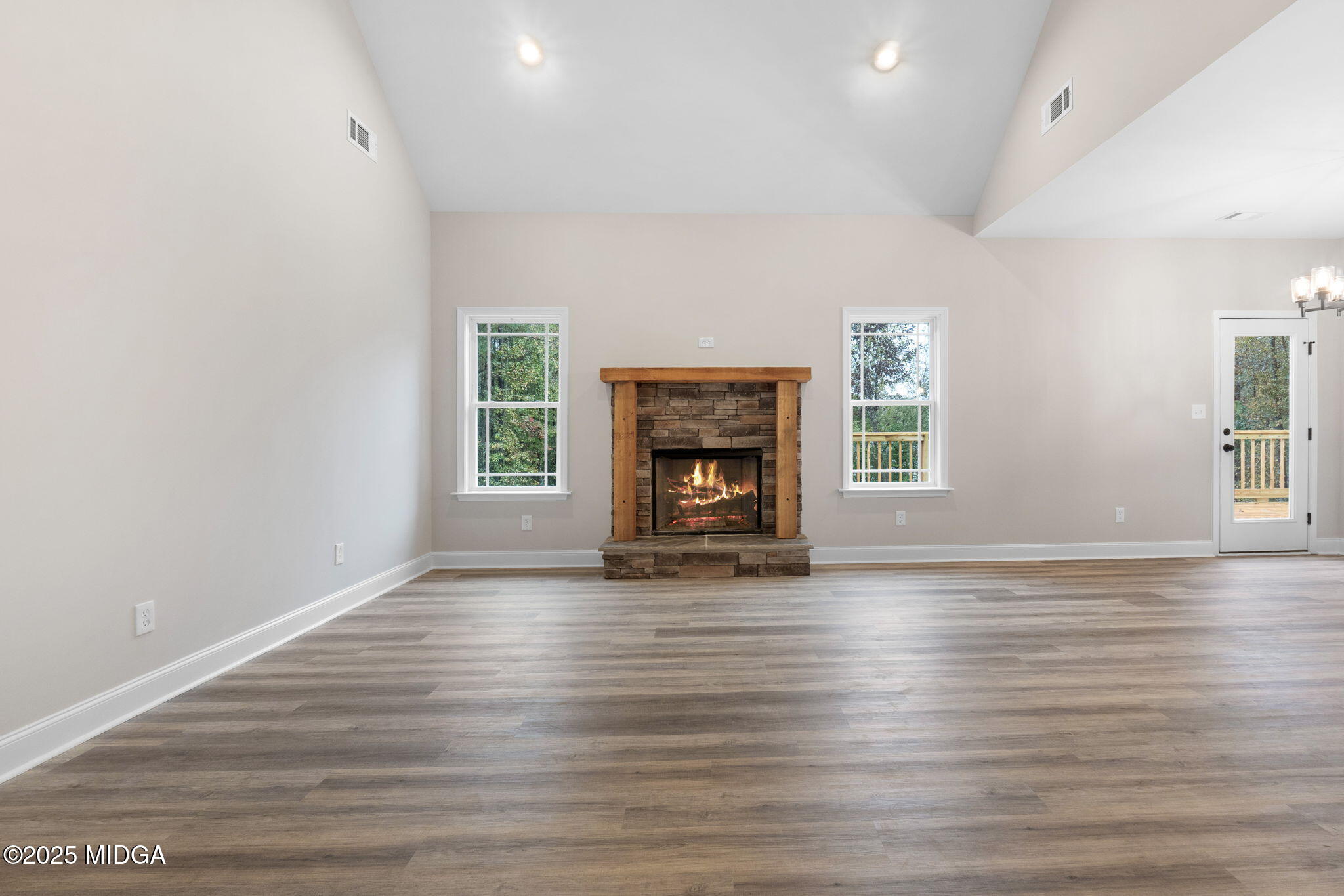 2754 Boxankle Road Forsyth, GA 31029 - Photo 8 of 53 an empty room with wooden floor fireplace and windows