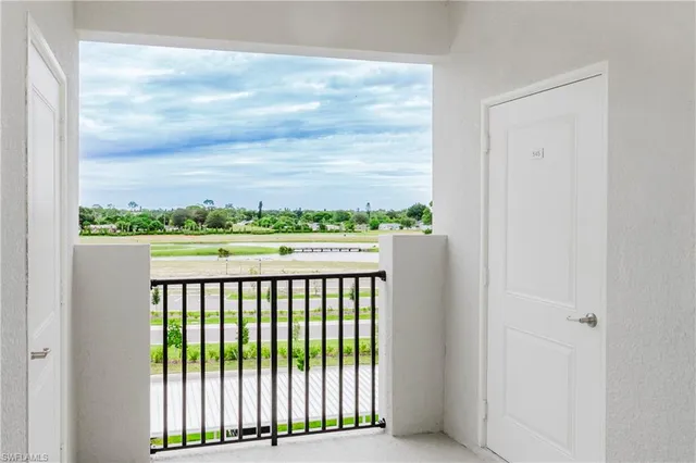 a view of a hallway with wooden floor and a bathroom