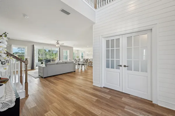 a view of a dining room with furniture a chandelier and wooden floor