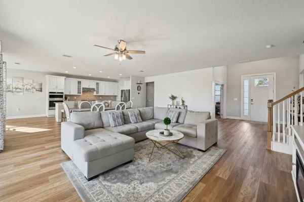 a view of a dining room with furniture wooden floor and kitchen view