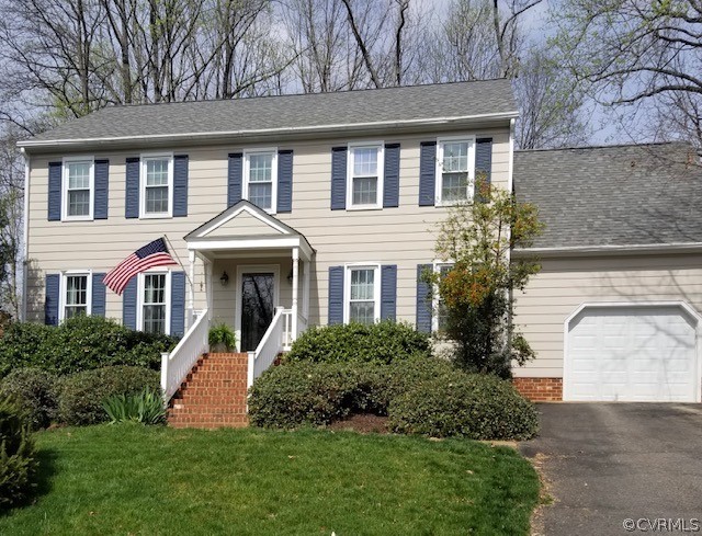 a front view of a house with a yard and trees