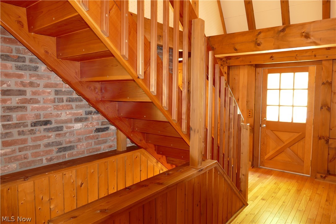 17340 Huntley Road Huntsburg, OH 44046 - Photo 11 of 24 Stairway featuring light hardwood / wood-style floors and wood walls
