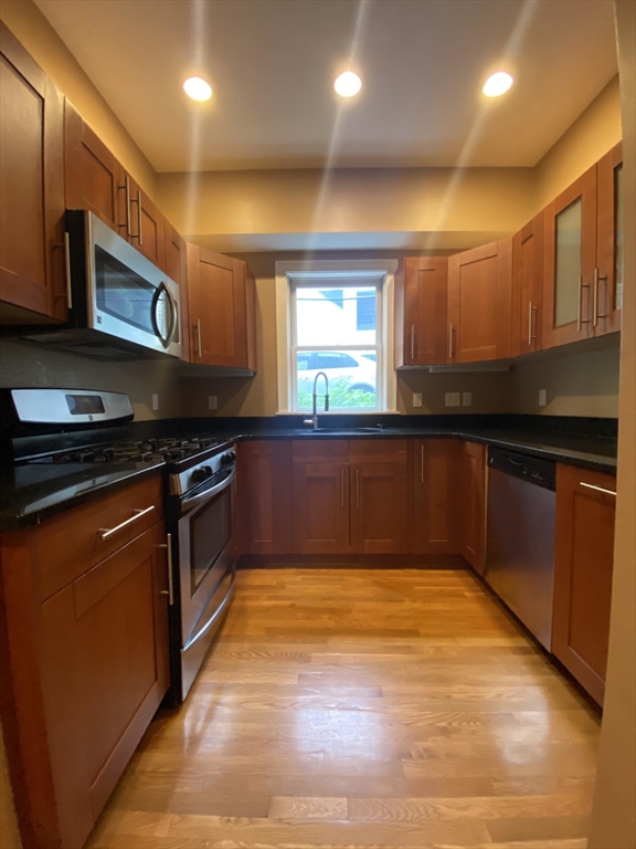 1592 Beacon Street, Unit 2 Brookline, MA 02446 - Photo 2 of 10 a kitchen with stainless steel appliances granite countertop a stove a sink and a microwave
