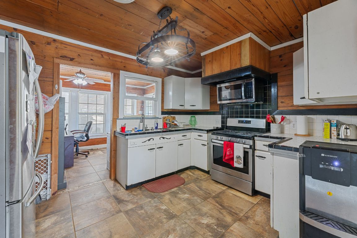 274 Old Potato Road Paige, TX 78659 - Photo 11 of 40 a kitchen with stainless steel appliances granite countertop a stove sink and cabinets