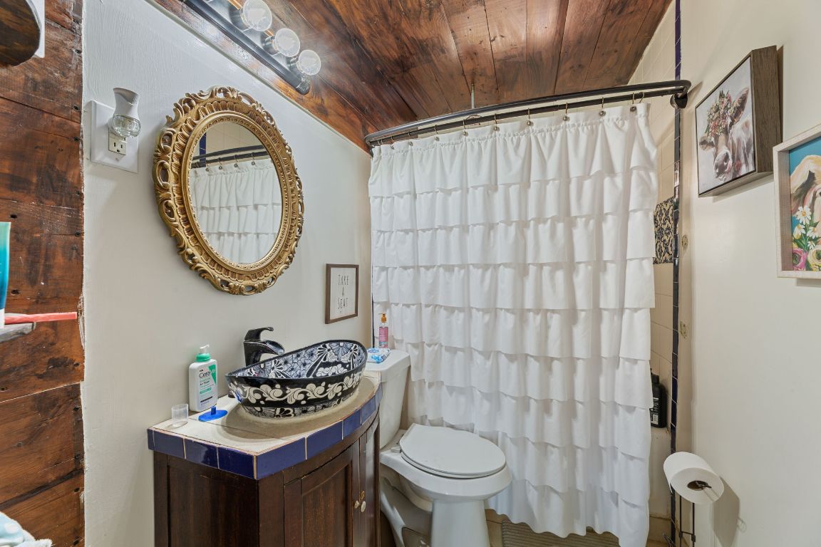 274 Old Potato Road Paige, TX 78659 - Photo 19 of 40 a bathroom with a toilet sink vanity and mirror