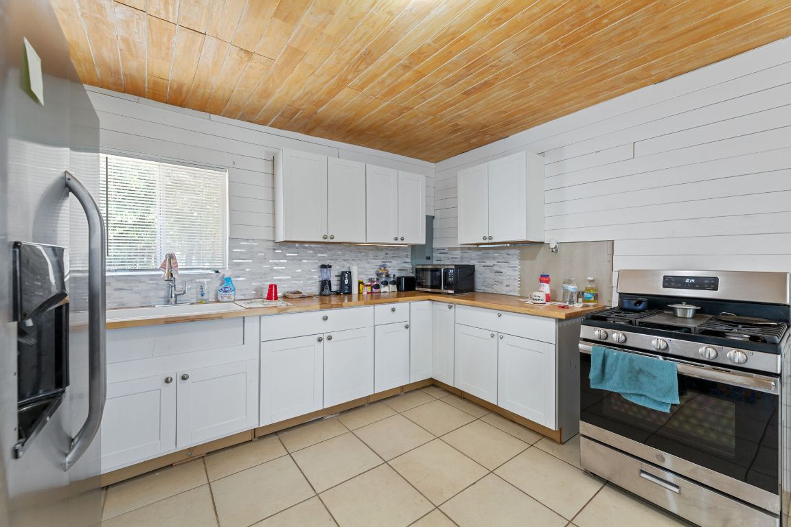 274 Old Potato Road Paige, TX 78659 - Photo 25 of 40 a kitchen with granite countertop white cabinets stainless steel appliances and a sink