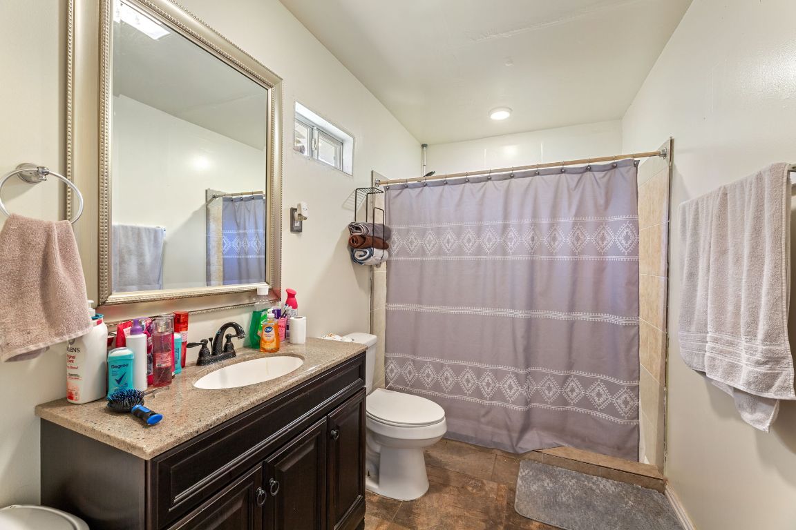 274 Old Potato Road Paige, TX 78659 - Photo 27 of 40 a bathroom with a shower sink vanity mirror and toilet
