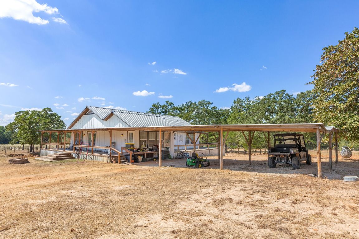 274 Old Potato Road Paige, TX 78659 - Photo 6 of 40 a view of a patio with a table and chairs under an umbrella with wooden floor