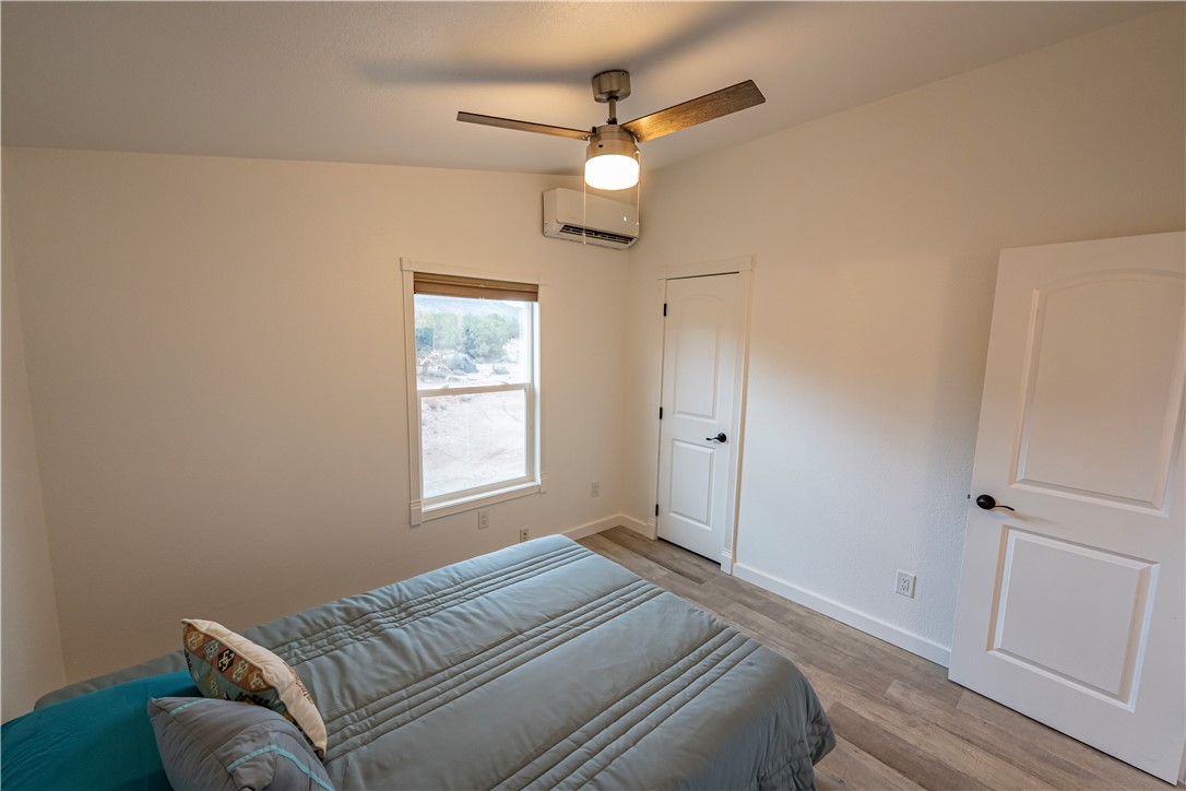 2765 North Silver Springs Road Kingman, AZ 86401 - Photo 25 of 60 a bedroom with a large bed chandelier and a window