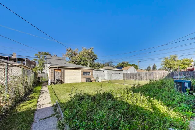 a view of a house with a yard and potted plants