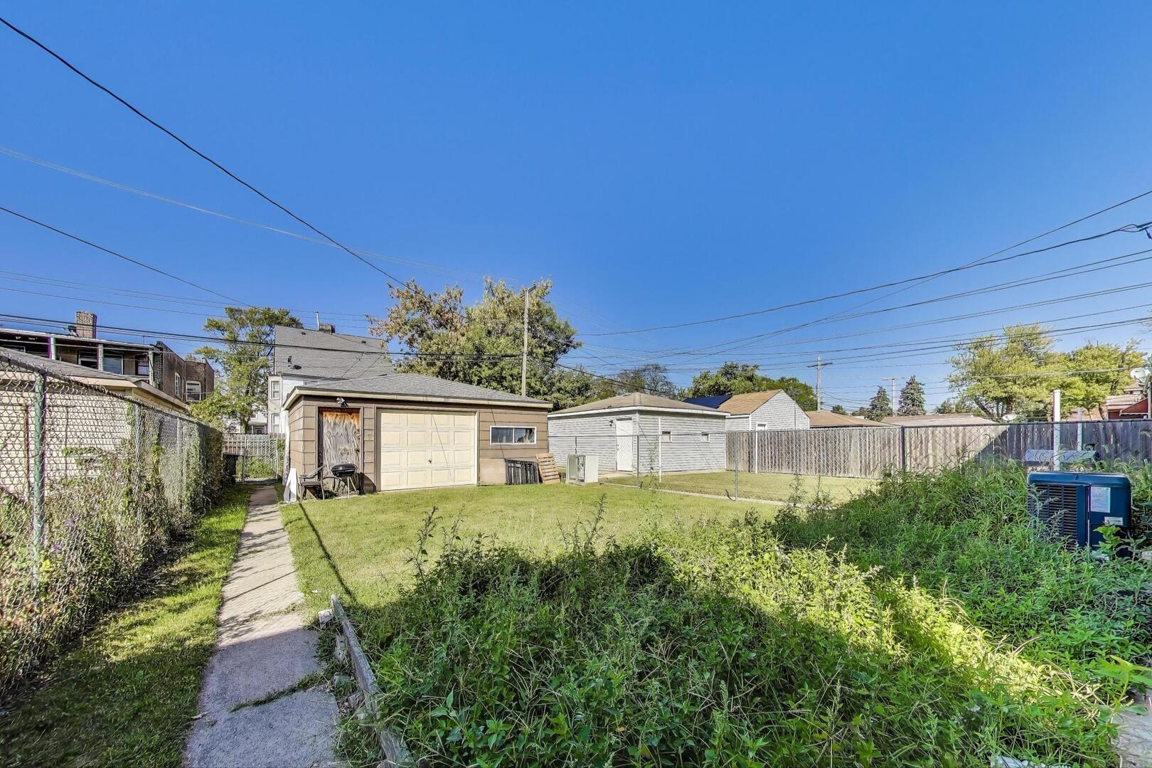 8822 South Ada Street Chicago, IL 60620 - Photo 24 of 25 a view of a house with a yard and potted plants