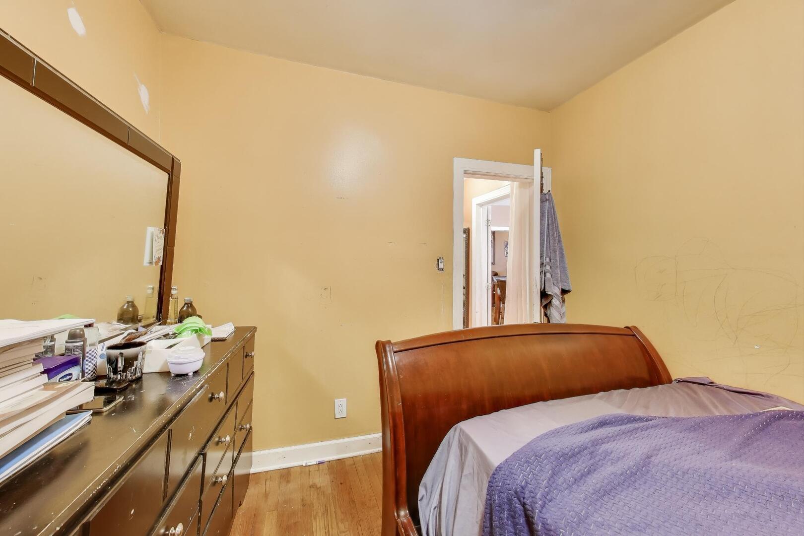 8822 South Ada Street Chicago, IL 60620 - Photo 8 of 25 a bedroom with a bed and a dresser next to a window