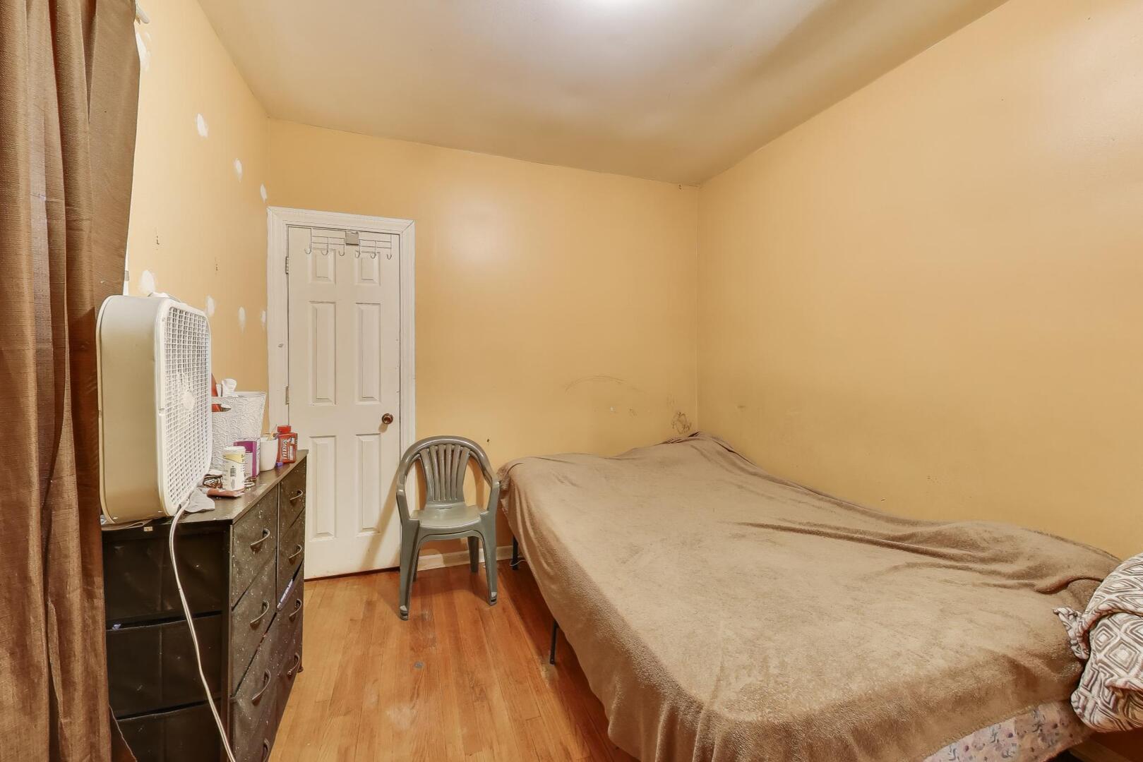 8822 South Ada Street Chicago, IL 60620 - Photo 9 of 25 a bed room with a bed and a chair