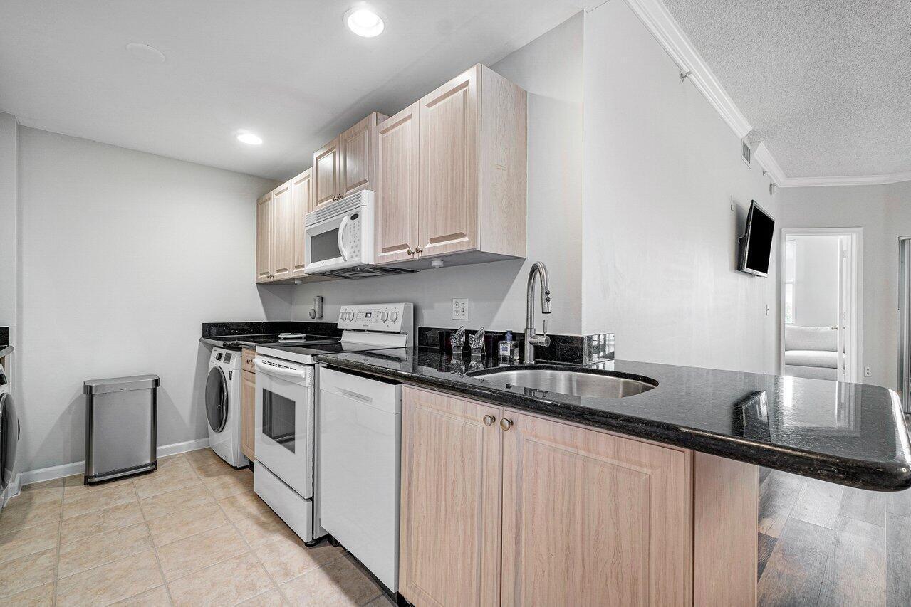 2040 Greenview Shores Boulevard, Unit 223 Wellington, FL 33414 - Photo 11 of 15 a kitchen with stainless steel appliances granite countertop a sink a stove and a refrigerator