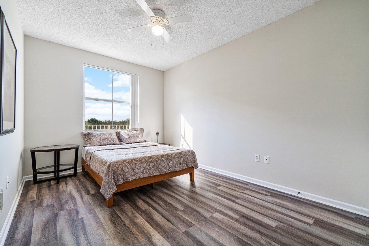 2040 Greenview Shores Boulevard, Unit 223 Wellington, FL 33414 - Photo 13 of 15 a bedroom with a bed and window