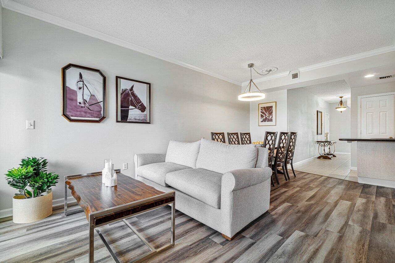 2040 Greenview Shores Boulevard, Unit 223 Wellington, FL 33414 - Photo 4 of 15 a living room with furniture and wooden floor