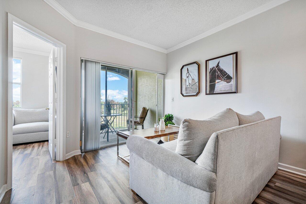 2040 Greenview Shores Boulevard, Unit 223 Wellington, FL 33414 - Photo 5 of 15 a living room with furniture and a large window