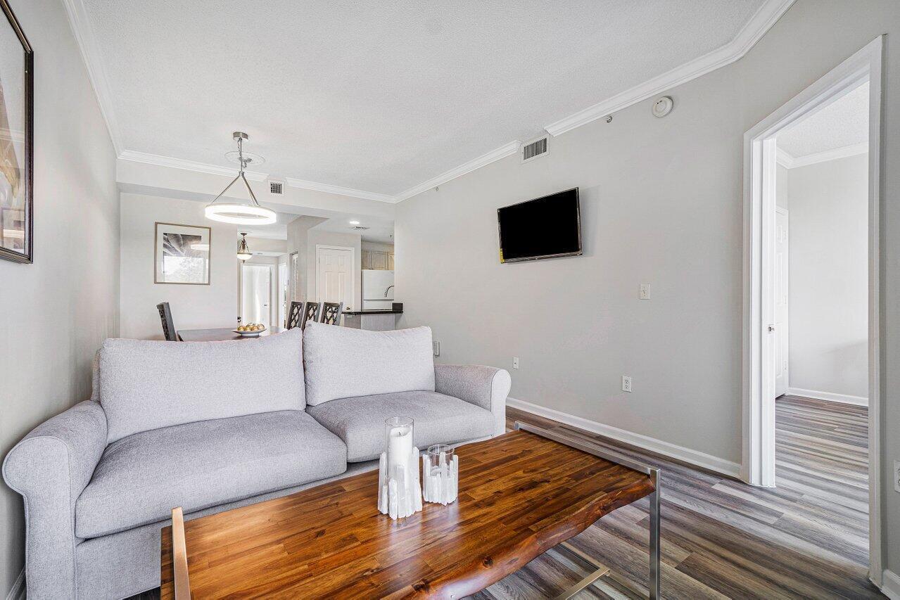 2040 Greenview Shores Boulevard, Unit 223 Wellington, FL 33414 - Photo 6 of 15 a living room with furniture and a flat screen tv