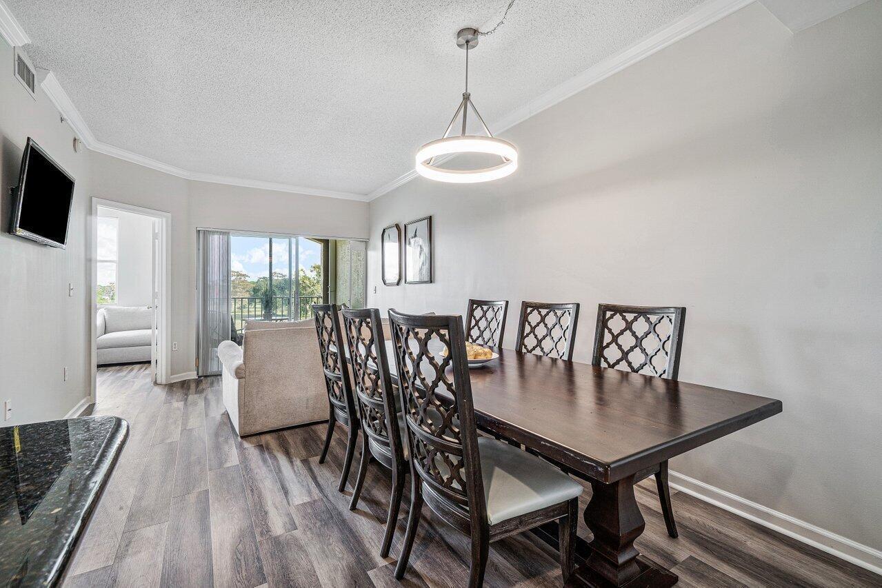 2040 Greenview Shores Boulevard, Unit 223 Wellington, FL 33414 - Photo 8 of 15 a view of a dining room with furniture window and wooden floor