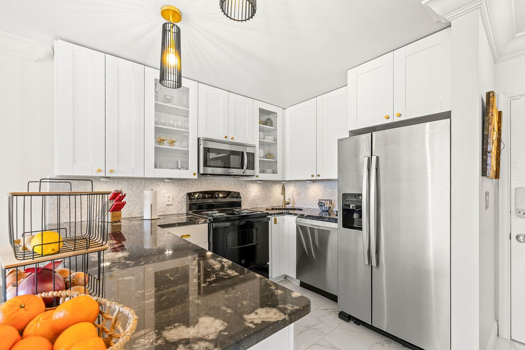 2400 South Ocean Drive, Unit 913 Fort Pierce, FL 34949 - Photo 9 of 36 a kitchen with stainless steel appliances granite countertop a refrigerator a stove top oven a sink and dishwasher