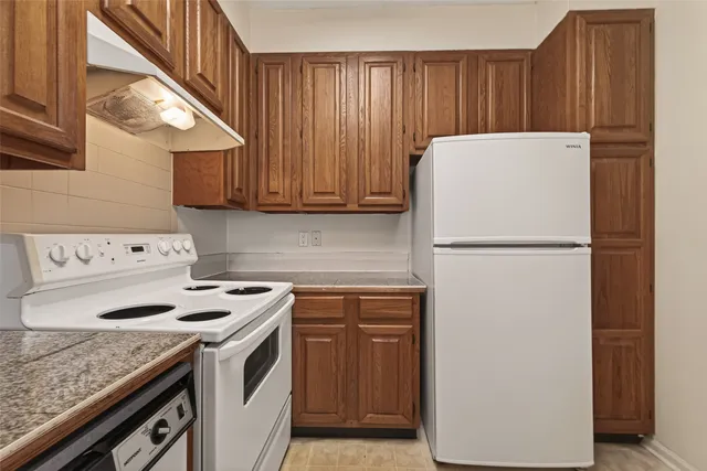 a kitchen with a stove a refrigerator and a sink
