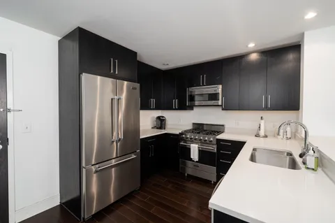 a kitchen with stainless steel appliances a refrigerator stove microwave and sink