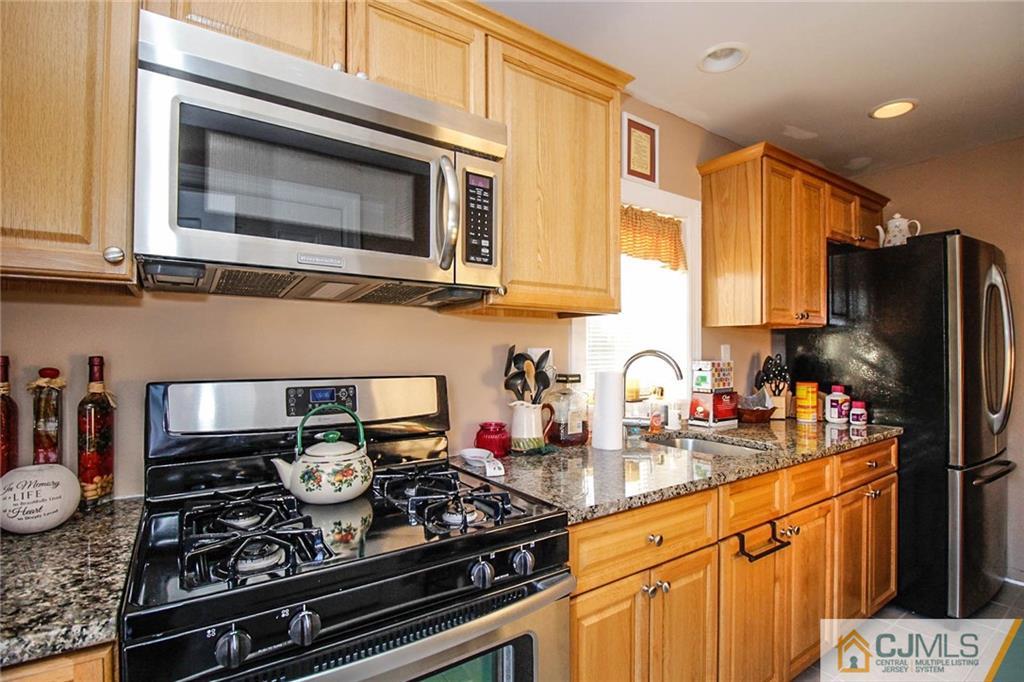 128 Morningside Road Colonia, NJ 07067 - Photo 21 of 25 a kitchen with stainless steel appliances granite countertop a stove a sink dishwasher and cabinets with wooden floor
