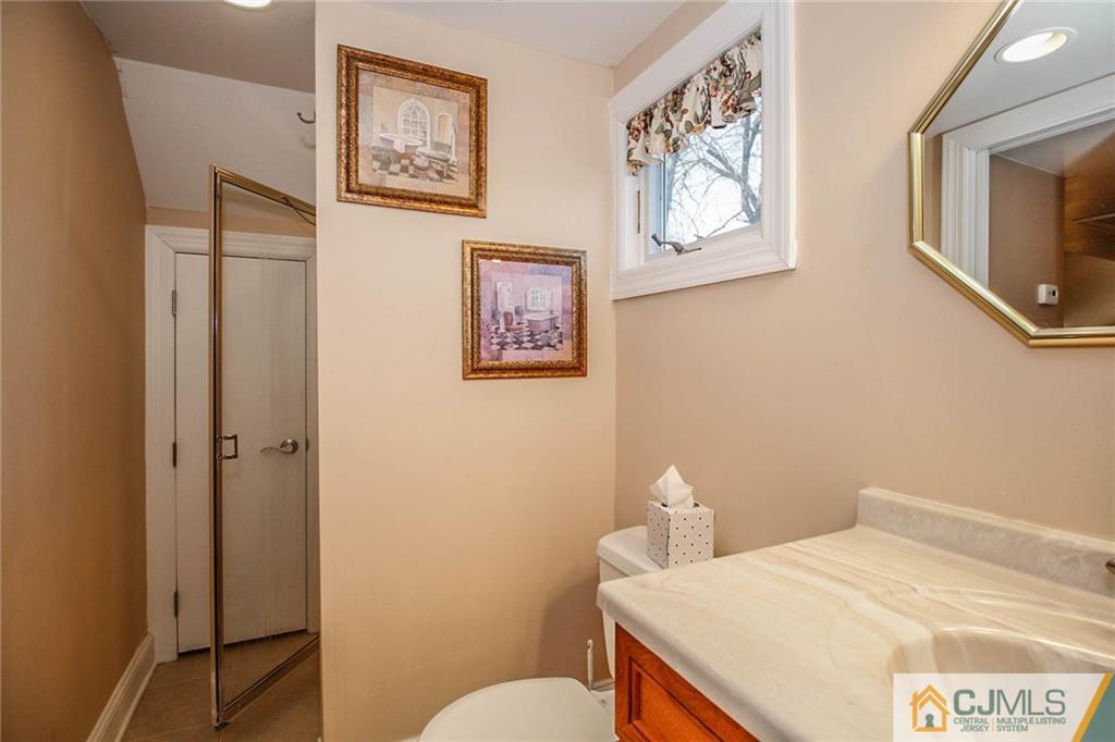128 Morningside Road Colonia, NJ 07067 - Photo 23 of 25 a bathroom with a sink a toilet and mirror