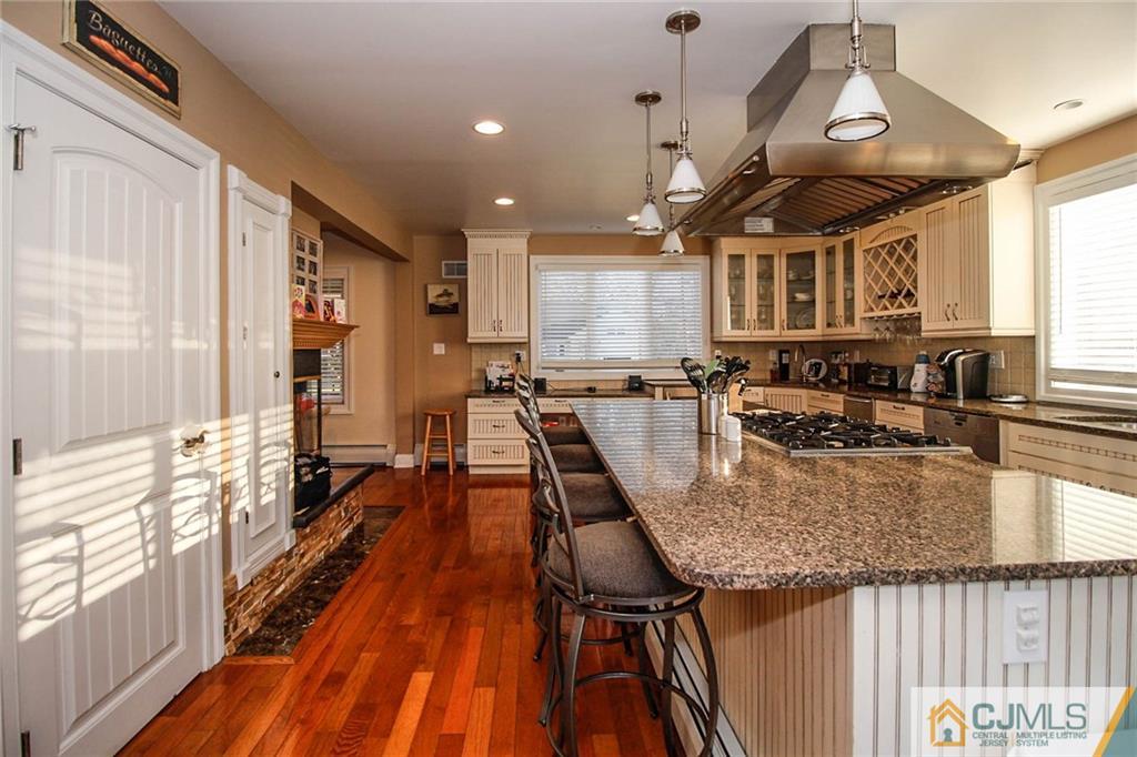 128 Morningside Road Colonia, NJ 07067 - Photo 8 of 25 an open kitchen with a table chairs stove and wooden floor
