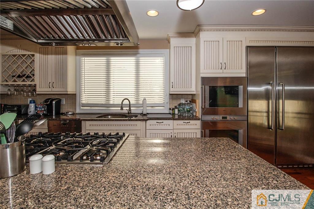 128 Morningside Road Colonia, NJ 07067 - Photo 9 of 25 a kitchen with stainless steel appliances a stove a sink and a refrigerator