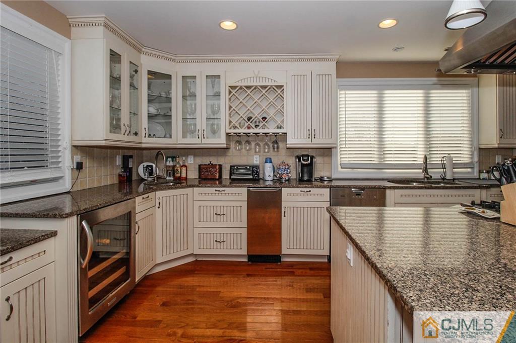 128 Morningside Road Colonia, NJ 07067 - Photo 10 of 25 a kitchen with stainless steel appliances granite countertop a stove a sink and white cabinets