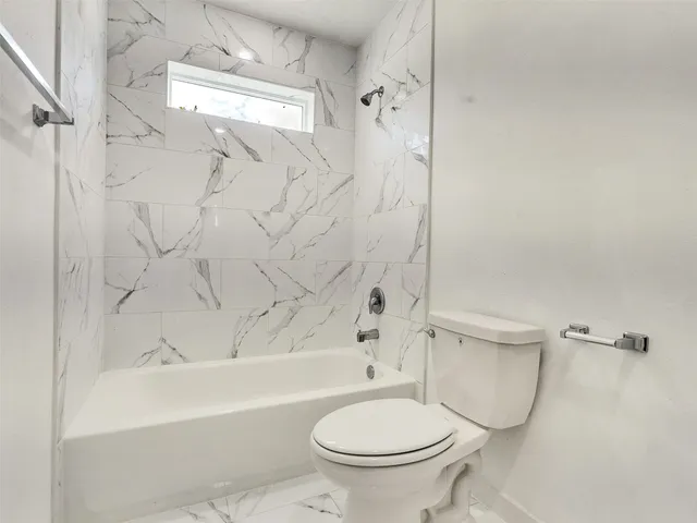 a large white kitchen with white cabinets and wooden floor