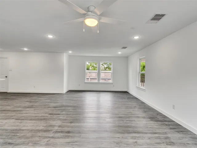 a view of a small space with wooden floor and a window