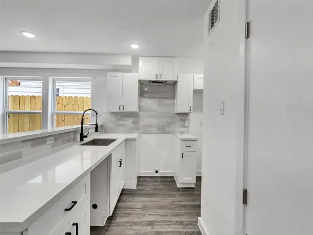 a bathroom with a granite countertop sink a toilet and bathtub