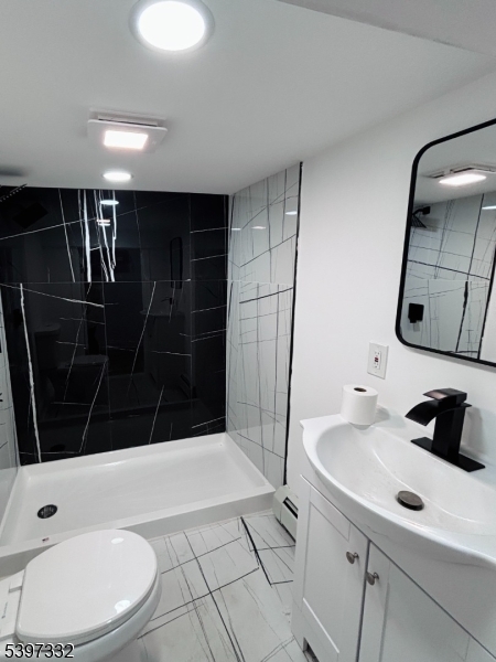 48 North York Street, Unit 1F Paterson, NJ 07524 - Photo 18 of 18 a bathroom with a sink a toilet a mirror and shower