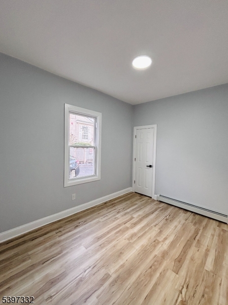 48 North York Street, Unit 1F Paterson, NJ 07524 - Photo 7 of 18 a view of an empty room with wooden floor and a window